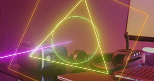 Animation of neon shapes over video game computer equipment. Global video game, digital interface, data processing and connections concept digitally generated video.