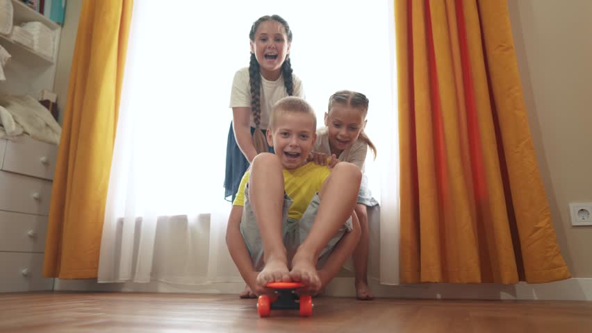 Small children play at home and ride skateboard. happy family childhood dream concept. a group of little kids having fun together at home in a bright room. children smiling lifestyle and laughing | Shutterstock HD Video #1108508473