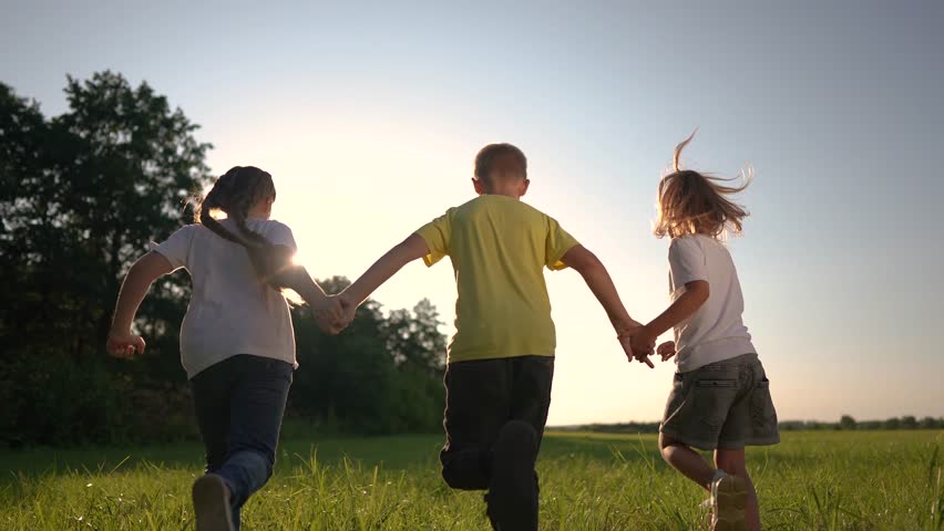 children running across field holding hands. happy family childhood dream concept. several children run on the grass in lifestyle summer and have fun together. kids run on the grass at sunset Royalty-Free Stock Footage #1108508477