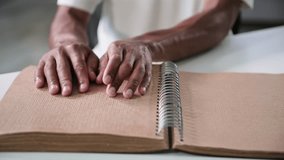 blind black young man reading a book for people with vision problems running his fingers along page, close-up - Powered by Shutterstock - Get 15% off with code: PIKWIZARD15