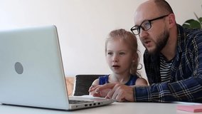 Dad helps daughter to do homework from internet.