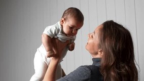Happy young mom with her cute infant baby girl. Mother playing with cute funny baby, having fun together indoors. Concept of maternity, motherhood, parenthood, childhood - Powered by Shutterstock - Get 15% off with code: PIKWIZARD15