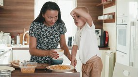Happy mom and son kid preparing tortillas for breakfast, cooking in home kitchen together - Powered by Shutterstock - Get 15% off with code: PIKWIZARD15