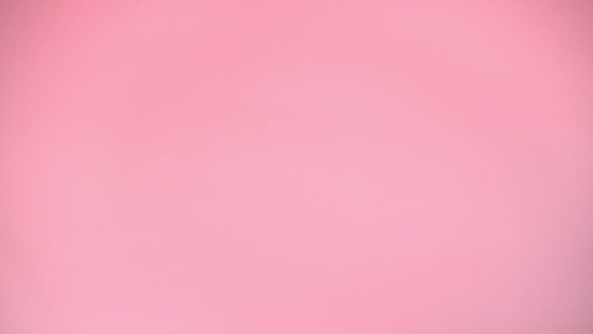 colorful sprinkles falling on pink background, decoration for cake and bakery, slow motion, top view