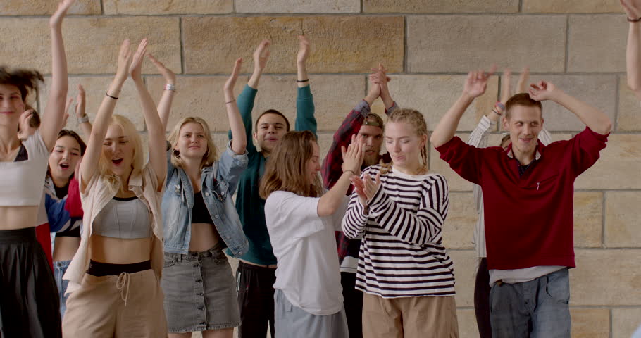 Group of young people Jumping and clapping hands, expressing happiness joy excitement. Celebrating special occasion, achievement, or simply having fun. Part of a dance routine. Students lifestyle. | Shutterstock HD Video #1108521985