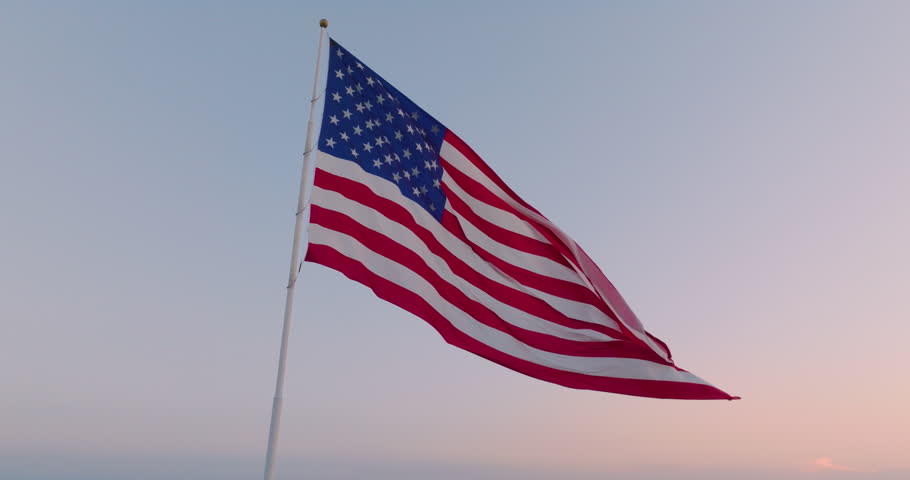 Cinematic view of an American flag waving in the wind at dusk as a symbol of freedom, July 4th, Independence Day, and the pride of the USA for democracy and politics in this epic scene. | Shutterstock HD Video #1108524683