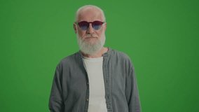 Green Screen. A Smiling Old Man with a Gray Beard in the Funny Glasses Shows Two Thumps Up. Travel Health and Safety for the Elderly.