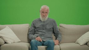Green Screen. A Poor Old Man with Gray Beard Counting His Money in US Dollars. An Elderly Man is Stressed by the Amount of US Dollar Money in His Wallet. Poverty in a World of Older People.