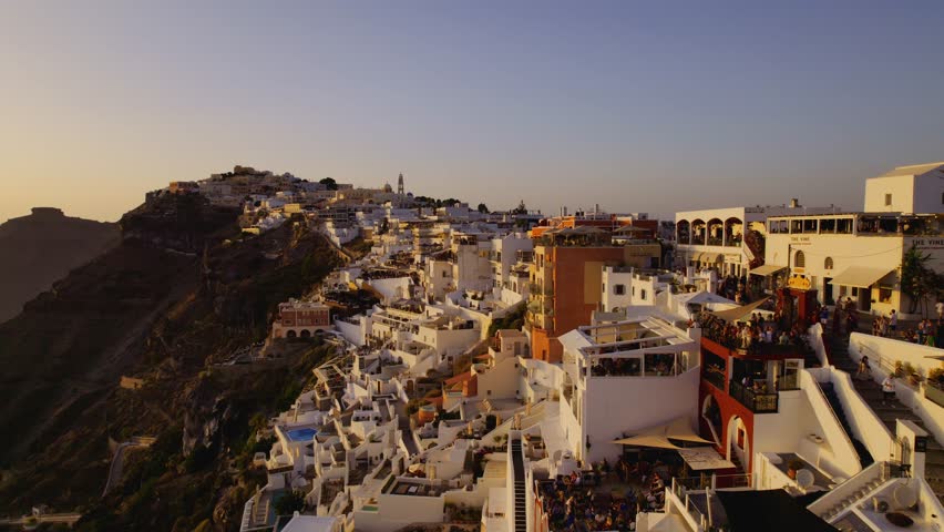 Aerial view of Santorini's coastal buildings at sunset in Greece. Cinematic 4k. | Shutterstock HD Video #1108526395
