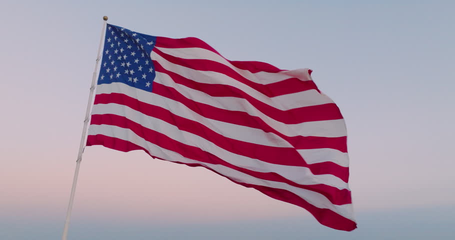 Cinematic view of an American flag waving in the wind at dusk as a symbol of freedom for political elections for Democratic or Republican ads for candidates in the United States of America or USA. | Shutterstock HD Video #1108531681