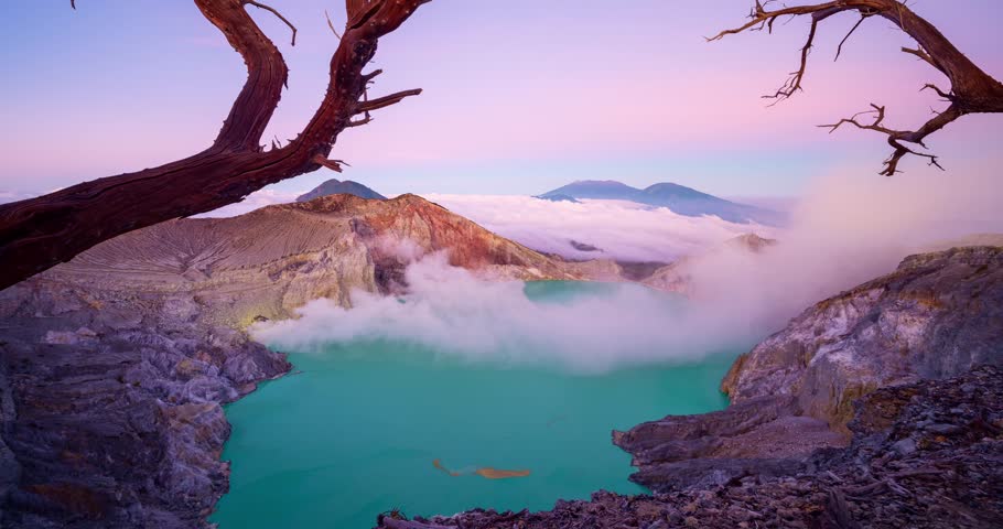 Timelapse of rock cliff at Kawah Ijen volcano with turquoise sulfur water lake at sunrise.Amazing nature landscape view at East Java, Indonesia.Natural landscape background.Deadwood Leafless Trees  Royalty-Free Stock Footage #1108533731