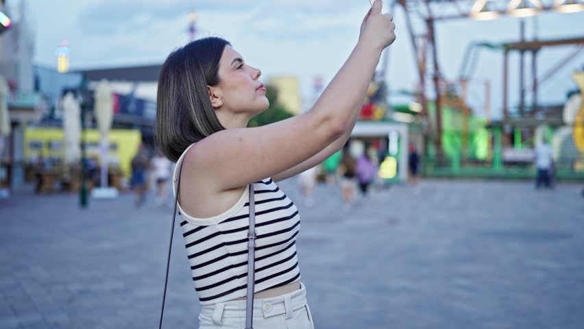 Young beautiful hispanic woman smiling happy using smartphone at Prater Vienna