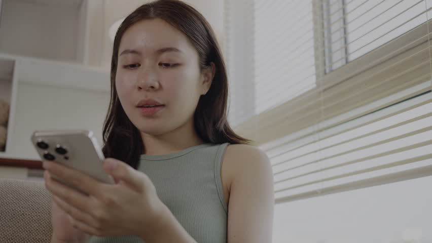 Young Woman in Happy Conversation with Friends on Smartphone, Smiling Woman Engages in Joyful Phone Chat, Digital Connection, Modern Communication. Royalty-Free Stock Footage #1108538361