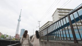 Happy Asian woman friends walking exercise on footpath by the river together in Tokyo city, Japan in the morning. Attractive girl enjoy outdoor lifestyle travel city in autumn winter holiday vacation. - Powered by Shutterstock - Get 15% off with code: PIKWIZARD15