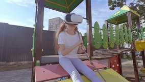 Girl child plays a game in a virtual reality helmet. She goes in for sports in virtual reality glasses.