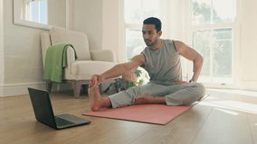 Man, yoga and stretching on computer for home training, fitness and holistic or wellness in virtual class or video streaming. Young person on floor for workout, exercise and muscle health on laptop