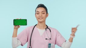 Nurse, woman and phone green screen, yes for healthcare and video presentation, advice or review on a blue background. Face, doctor or medical student with mobile mockup and tracking marker in studio