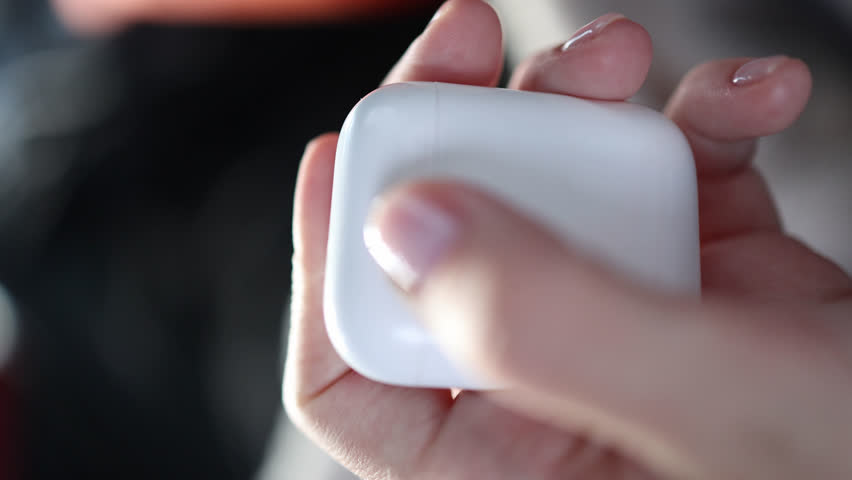 Woman's hand opens a small white case with portable earphones. vertical video | Shutterstock HD Video #1108547459