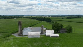 Aerial hyperlapse of family farm in rural USA surrounded by cornfields in summer. Bright, windy afternoon with clouds moving. Drone timelapse. - Powered by Shutterstock - Get 15% off with code: PIKWIZARD15