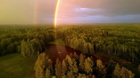 A Beautiful Double Rainbow Reflecting Colorful Light Over a Scenic Lake and Forest in Latvia. Aerial Drone Tracking Shot. - Powered by Shutterstock - Get 15% off with code: PIKWIZARD15