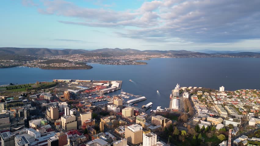 Hobart, Australia: Aerial drone footage of the Hobart central business district and Wharf harbor in Tasmania main city on a sunny day. Shot with a backward motion