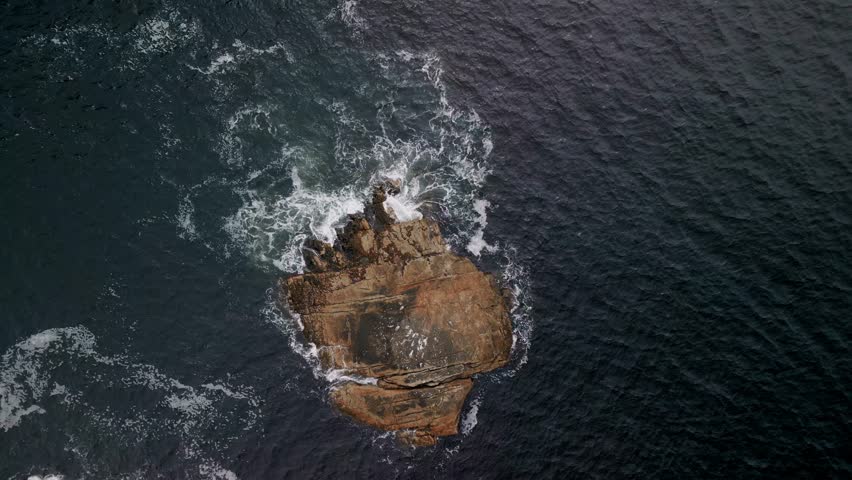 Top Down View of a Rocky Island in the Ocean and Waves Crashing Against the Rocks on a Foggy Cloudy Day in Nova Scotia, Canada.Rocks and Waves the Atlantic Ocean Crashing on a Small Island in Ocean