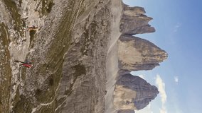 Aerial vertical shot of group of friends hiking Tre Cime National Park Three Peaks of Lavaredo beautiful epic mountain peaks. Travel exploring Alps Dolomites Italy nature outdoor