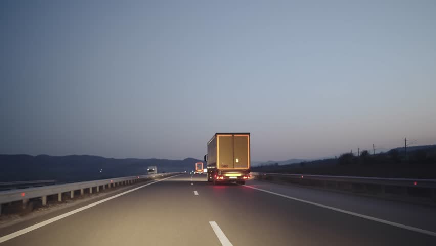 Truck driving on the asphalt highway road at sunrise, twilight,dawn Royalty-Free Stock Footage #1108557391