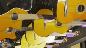 A large selection of acoustic guitars in the music store. Vertical video