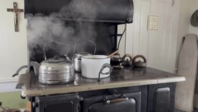 A vintage tea kettle boiling on the stove.