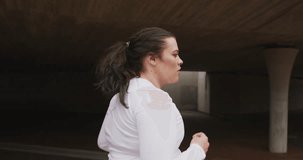 Animation of data processing over plus size caucasian woman running in city street. Sports, active lifestyle, urban living and happiness concept digitally generated video.