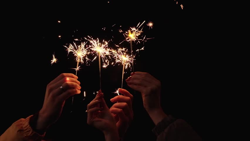 Hands of people with sparklers celebrating New Year