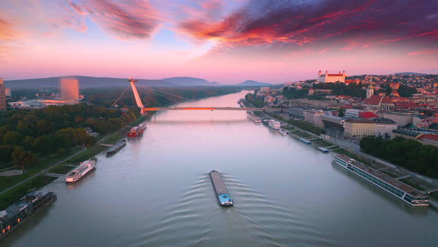 Bratislava city skyline aerial view, drone footage fly over Bratislava slovakia old town and river bridge at sunset. In front bratsilava castle.