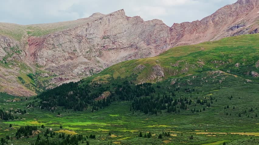 Drone side to side trucking pan establishes epic colorado ridgeline mountain and vibrant green guanella pass