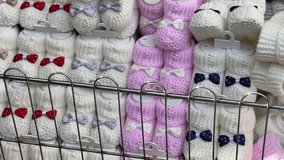 Hand knitted wool baby booties Macro Detail shot different alternative colors abstract pastel background image natural 4K video shooting buying now. 