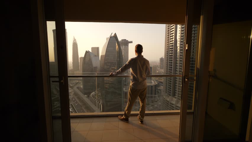 Young Man Succeed In High Rise Apartment Looking at Urban Buildings Royalty-Free Stock Footage #1108572655