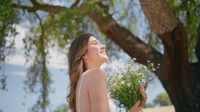 Coquettish girl hold daisies bouquet walking garden closeup. Flirty lady looking camera enjoying summer nature portrait. Joyful happy woman spinning with wildflowers having fun at countryside field - Powered by Shutterstock - Get 15% off with code: PIKWIZARD15