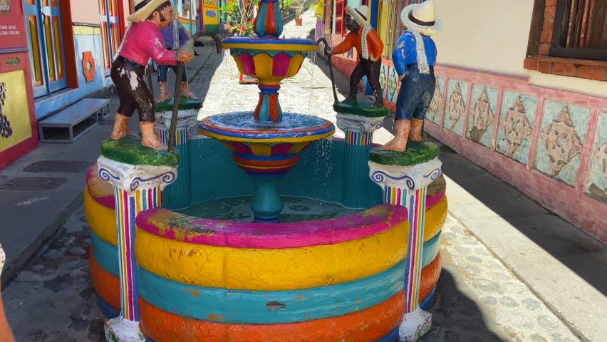Colorful and picturesque fountain in traditional street of Guatape Colombian village. Tilt up