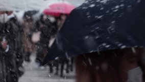 SHIBUYA, TOKYO, JAPAN - 6 JAN 2022 : Winter snow scenery around Shibuya crossing. Unidentified crowd of people at the street. Japanese urban city winter season and Christmas concept. Slow motion video