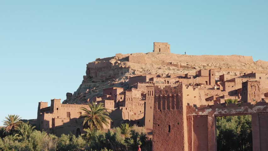 Close view of traditional mud buildings and palm trees in Ait Ben Haddou, Morocco.