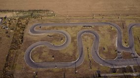 Aerial 4k footage of a karting race track. Drone shot of a Kart Circuit. Short circuit karting racing seen from above. High angle video of carts racing on a track.
