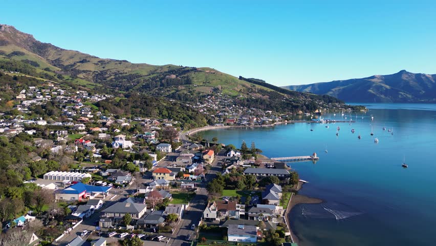 Akaroa, New Zealand: Aerial drone footage of the stunning Akaroa idyllic village in the Banks Peninsula in the Christchurch region of Canter bury in New Zealand south island on a sunny day. 
