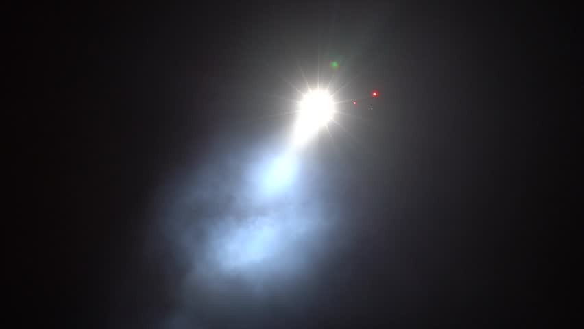 Helicopter Flying Overhead at Night with Bright Searchlight Beam