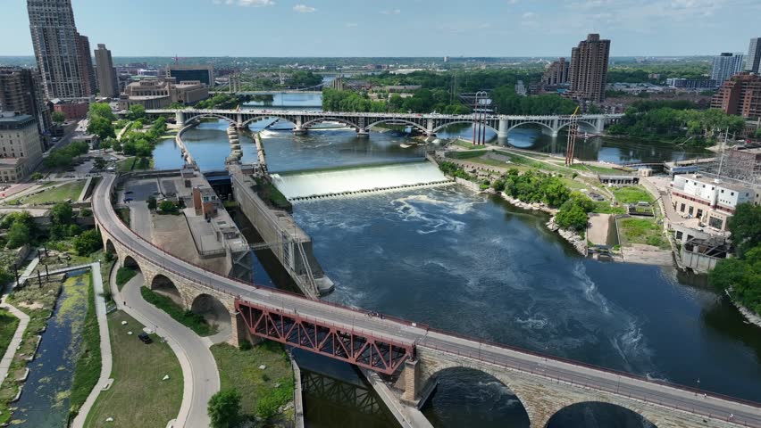 Mississippi River in Minneapolis, Minnesota. Stone Arch bridge and St Anthony Falls. Aerial establishing shot in summer.