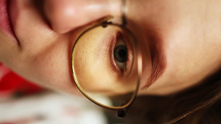 Half face of a girl in glasses. macro glasses eye woman. the girl poses for the camera. vertical video | Shutterstock HD Video #1108600903