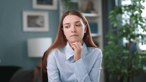 Female business analyst sits at desk in her office, looking at the camera during videochat, first-person view. Young and serious business woman having online conversation and listening intently