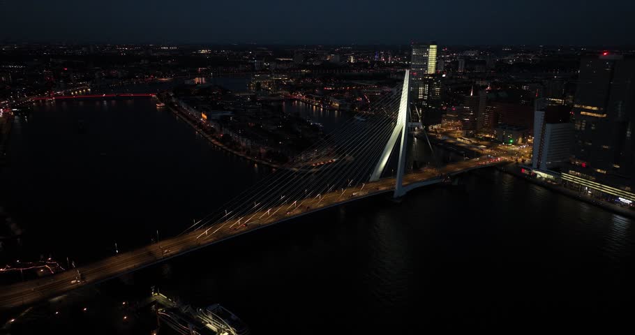 Aerial drone view of the Erasmusbrug, Erasmusbridge at night. Skyline of Rotterdam, The Netherlands.