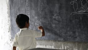 Asian school boy wearing uniform. Portrait of happy cute little indian boy in school uniform, Adorable elementary kid showing black board. child education concept. rural india. - Powered by Shutterstock - Get 15% off with code: PIKWIZARD15