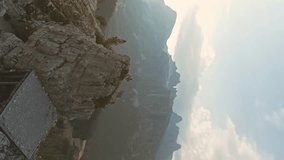 Aerial vertical shot man climbing on a top of a mountain peak Dolomites Alps. Summer adventure journey in nature outdoors. Travel exploring Alps, Dolomites, Italy