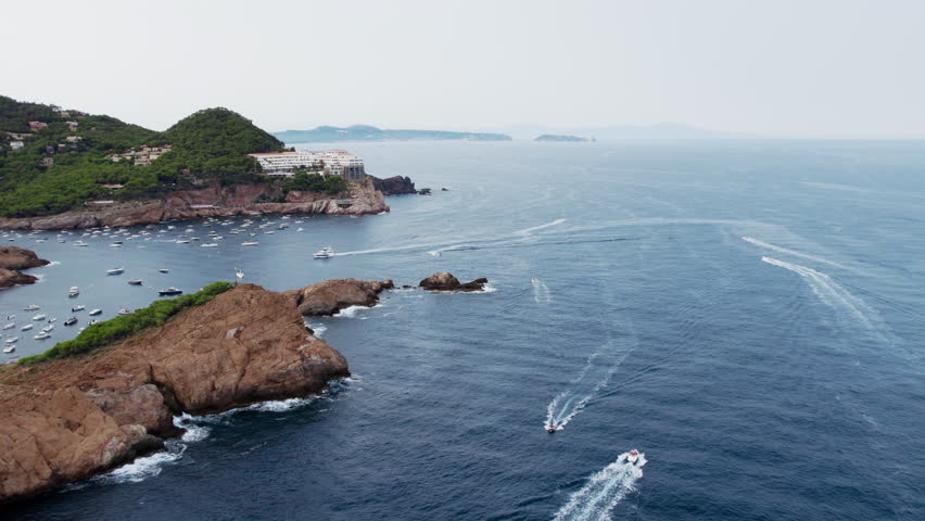 Heavy maritime traffic near Begur, Costa Brava, Spain. Aerial drone footage of private boats and small sailing yachts move in and out of natural bay or port. Cove and beach on Spanish seaside | Shutterstock HD Video #1108604167